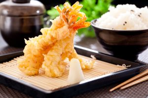 Juicy shrimp tempura on a plate with chopsticks