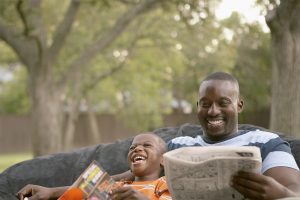 Father and son laughing and reading