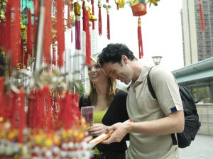 China, Hong Kong, couple looking at incense by Po Lim Temple