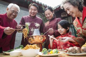 Family enjoying meal in traditional Chinese clothing