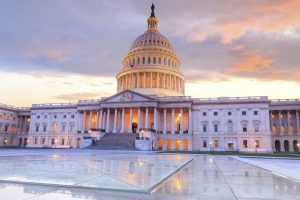 The United States Capitol building with the dome lit up at night.