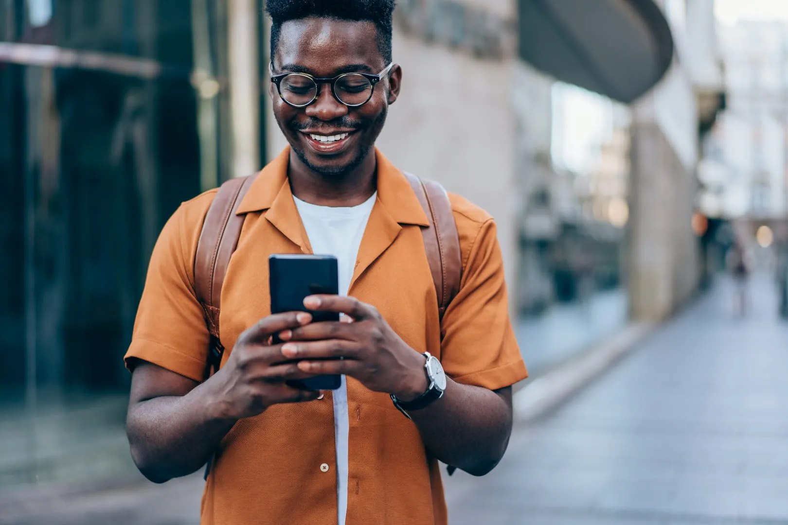 African american man using phone in street